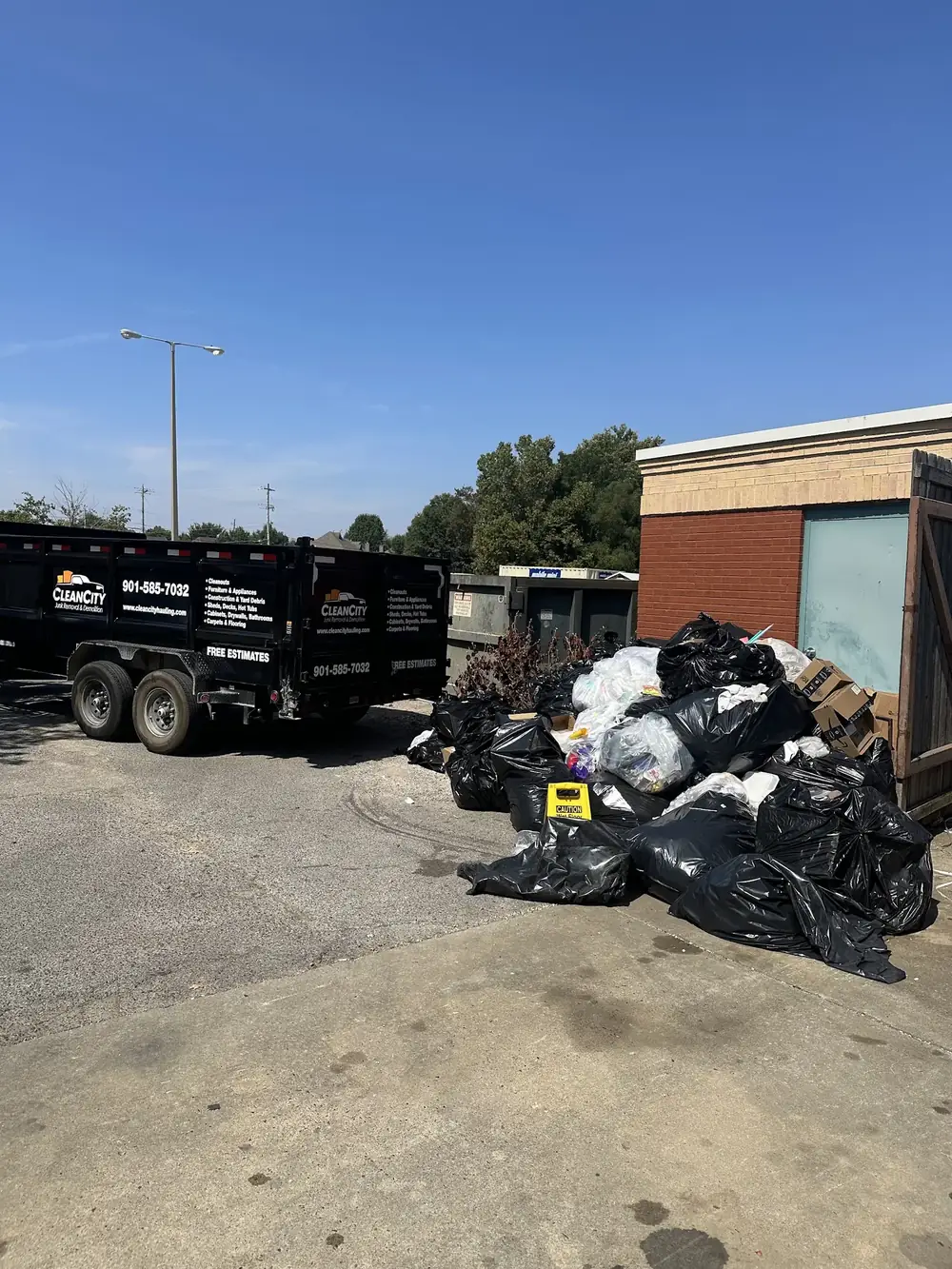 Bagged trash and debris being loaded beside a commercial building