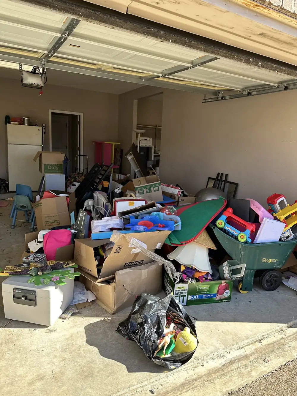 Before: a two-car garage piled with boxes, toys and household items