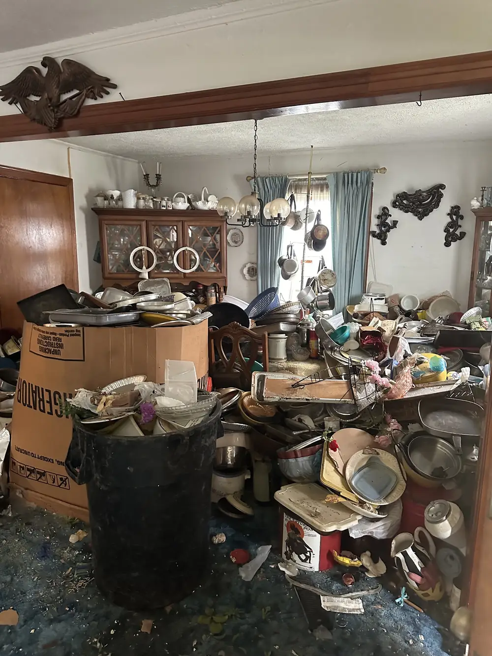 Before: a dining room buried in clutter around a china hutch