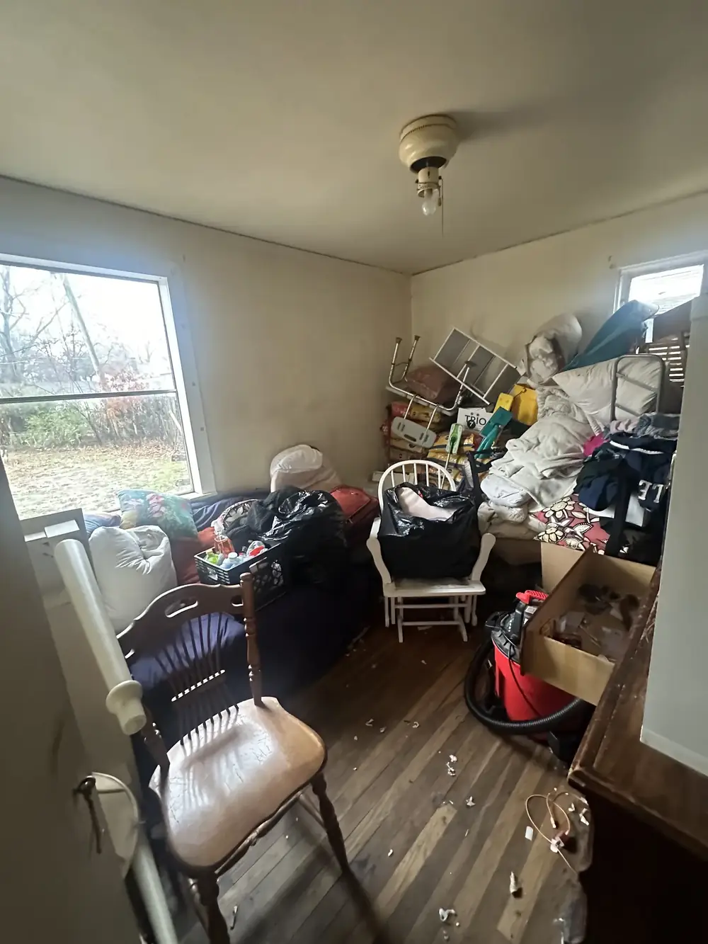 A bedroom full of furniture and belongings before a house cleanout