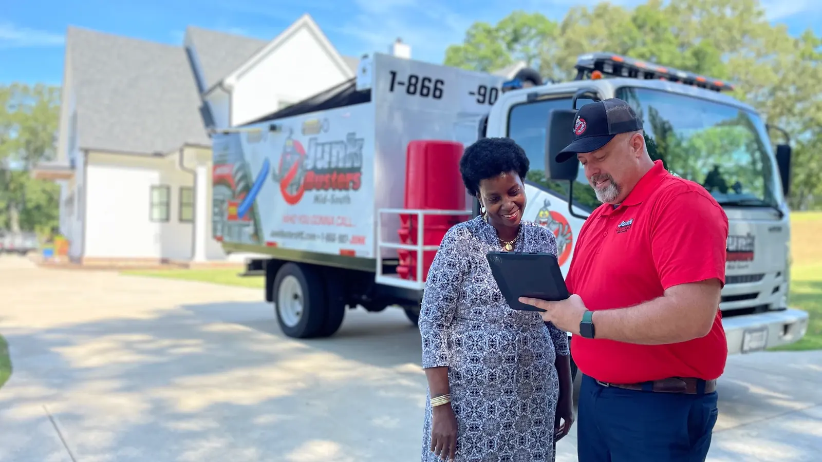 A Junk Busters crew lead going over an estimate with a customer beside the truck