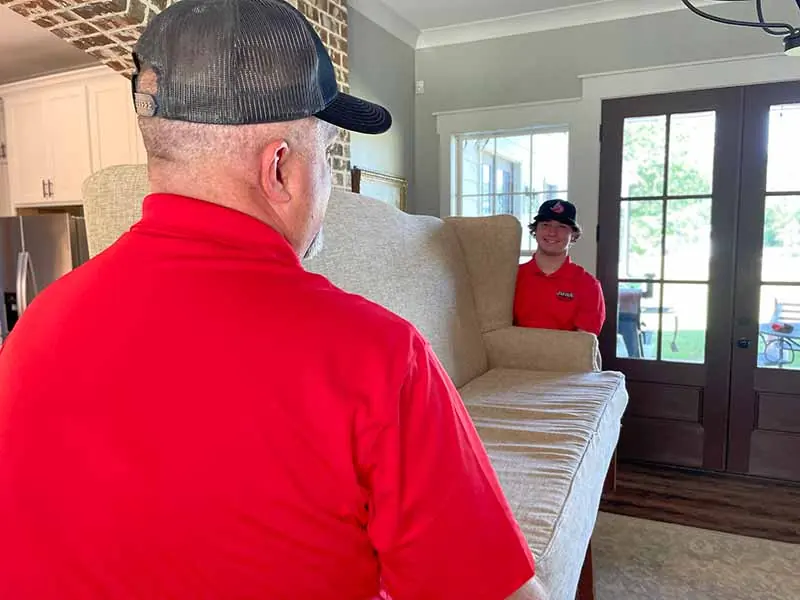 A Junk Busters crew member carrying out a couch