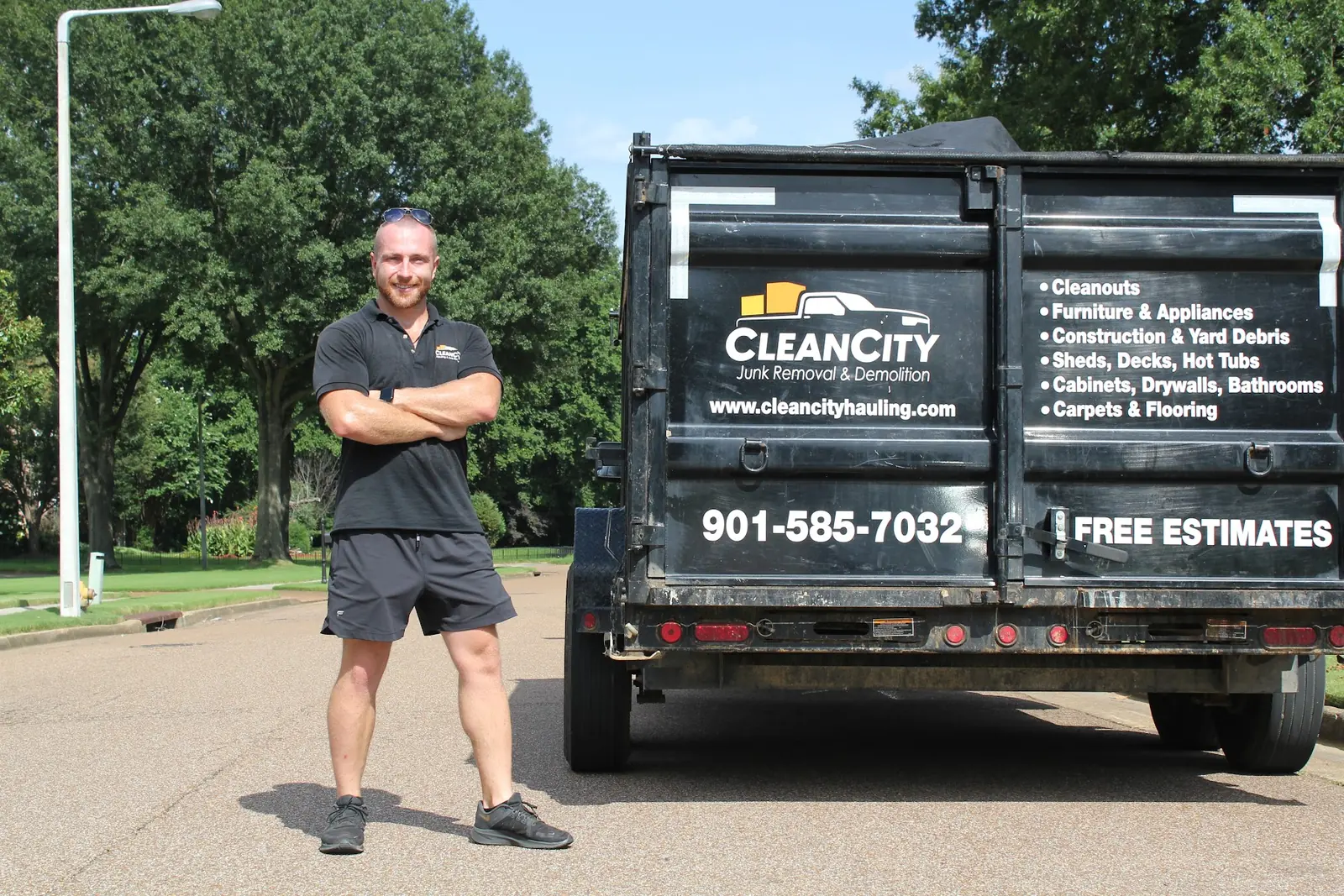 Clean City Hauling owner standing beside a Clean City dump trailer