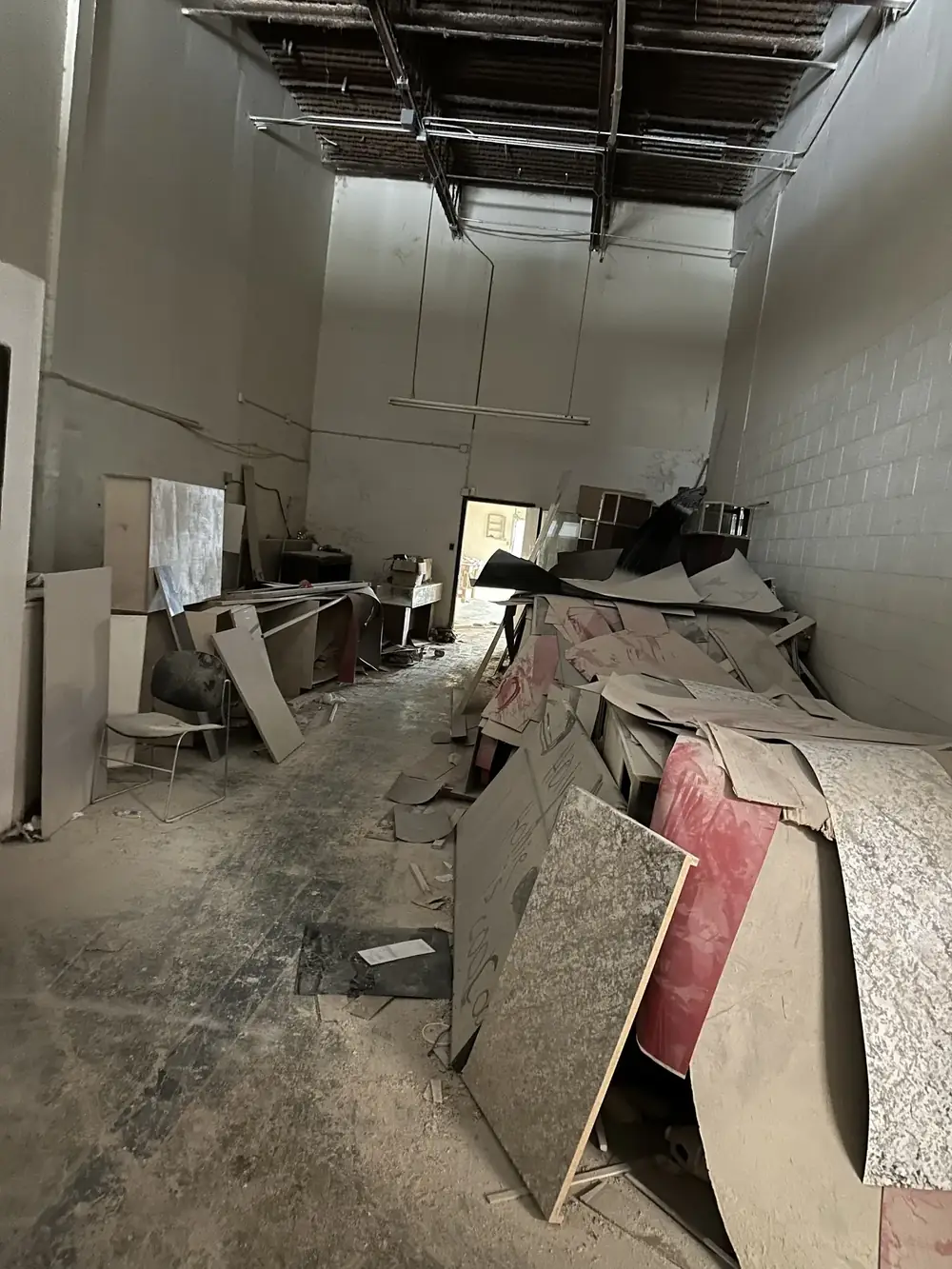 Debris and broken shelving inside a warehouse before cleanup