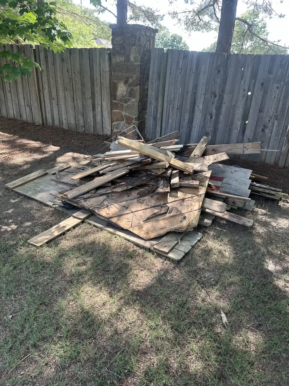 Before: a pile of old fence boards and debris in a backyard